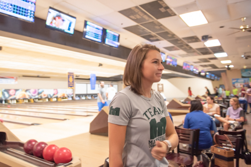 Woman snapping her fingers after missing pins at bowling alley